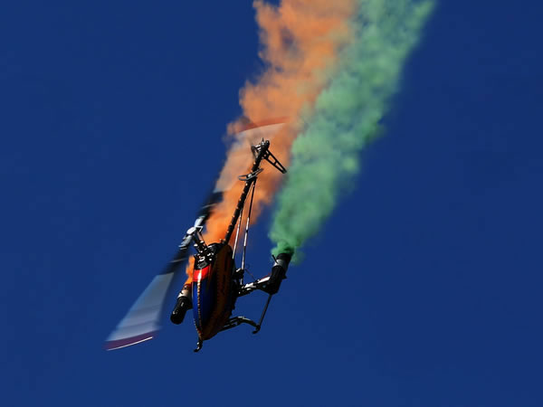 RC-Helikopter im Kunstflug vor blauem Himmel
